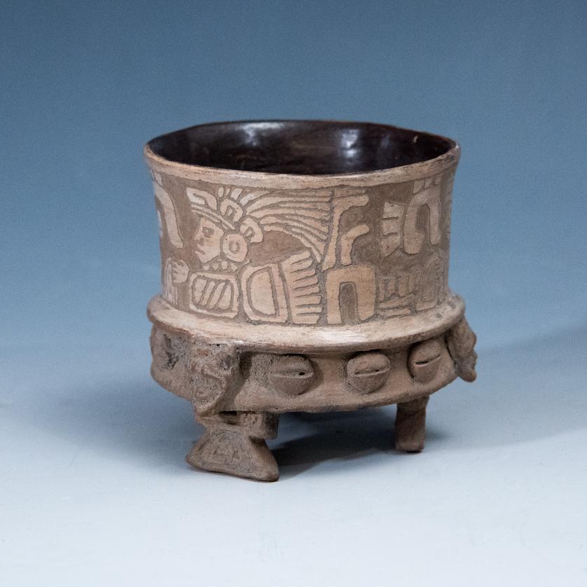 2090   -  ARQUEOLOGÍA. PREHISPÁNICO. Teotihuacán. Vaso trípode con decoración geométrica y antropomorfaincisa, en la parte inferior orla de rostros humanos y figuras geométricas aplicadae (ca. 100 a. C.- 650 d. C.) Cerámica policromada. Altura 6 cm.