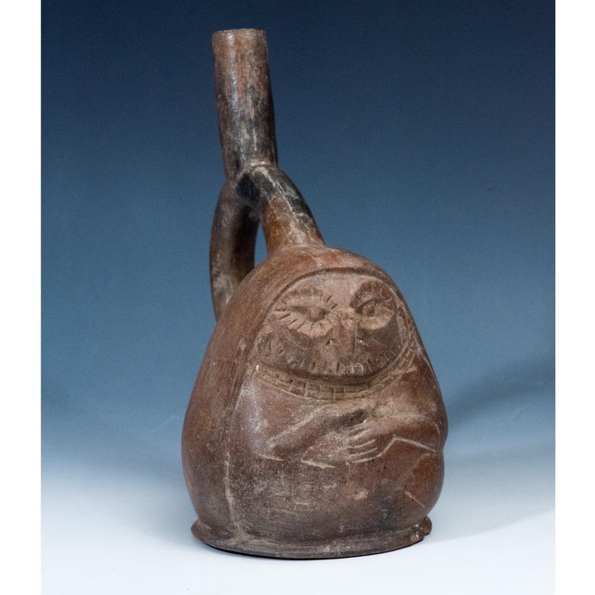 2095   -  ARQUEOLOGÍA. PREHISPÁNICO. Cultura Moche. Vaso de asa de estribo que representa una mujer con máscara de buho y cuenco en las manos (ss. II-VII d. C). Cerámica. Altura 21 cm.
