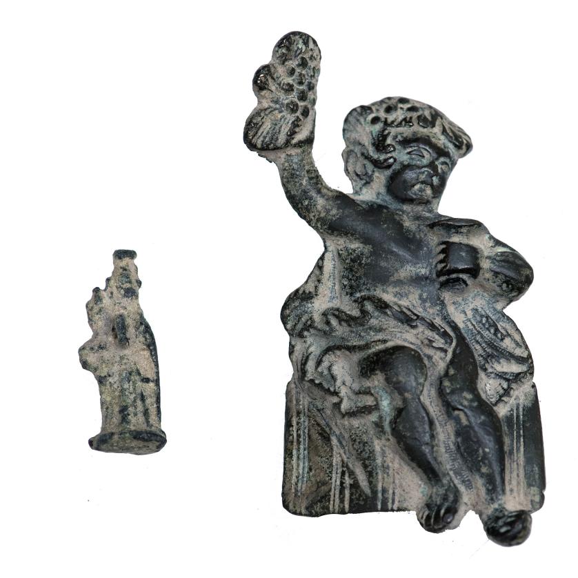 3025   -  ARQUEOLOGÍA. ROMA Y EDAD MODERNA. Lote de 2 figuras: figurilla de diosa romana y Baco niño como puti. Bronce. Entre 6,5 cm. y 2,7 cm.